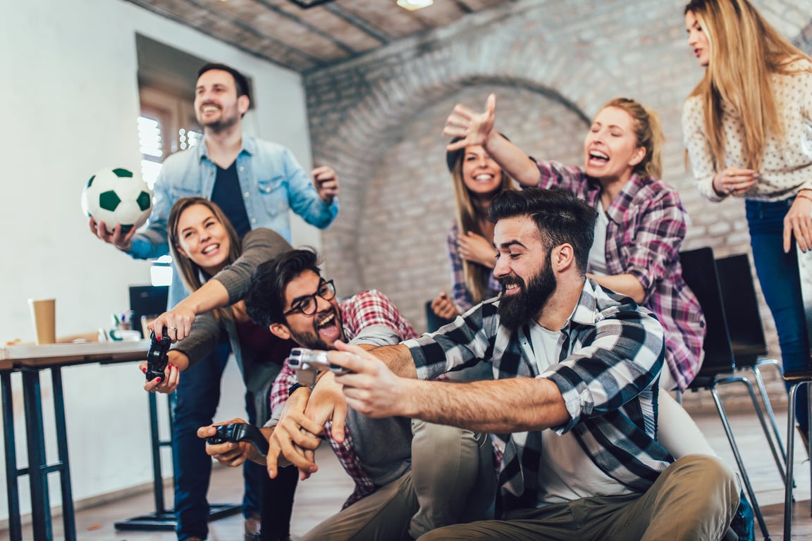 Coworkers playing video games in office